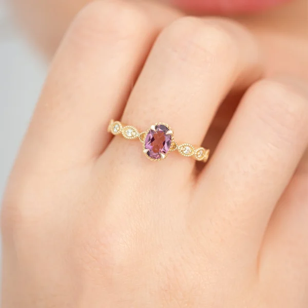 Ażurowy, złoty pierścionek z różowym, owalnym turmalinem z diamentami na obrączce